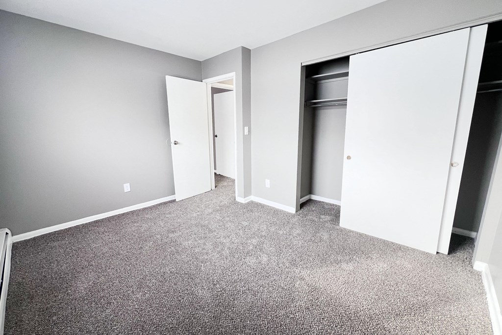 A room with grey carpet and white walls.