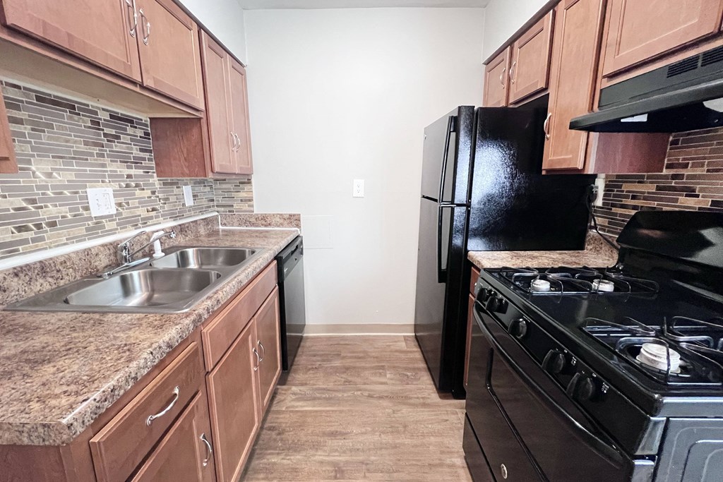 A kitchen with a black refrigerator and stove.