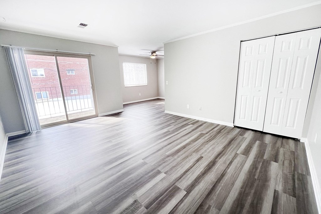 A room with wooden flooring and white walls.