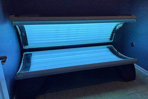 the bottom of an empty blue bunk bed in a blue room