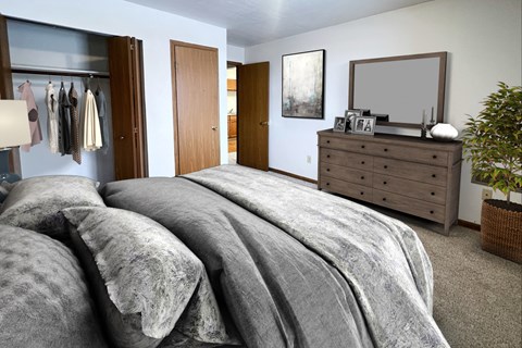 A bedroom with a large bed and a wooden dresser.