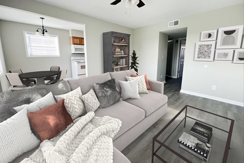 a living room with a gray couch and a glass coffee table
