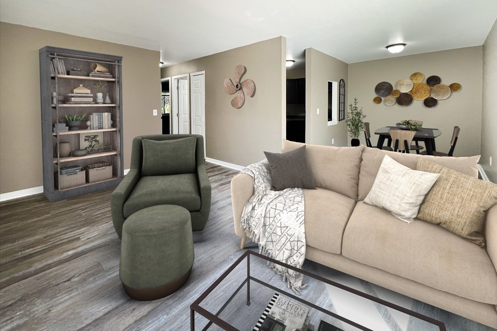 A living room with a green chair, a brown couch, and a wooden bookcase.