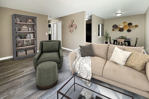 A living room with a green chair, a brown couch, and a wooden bookcase.
