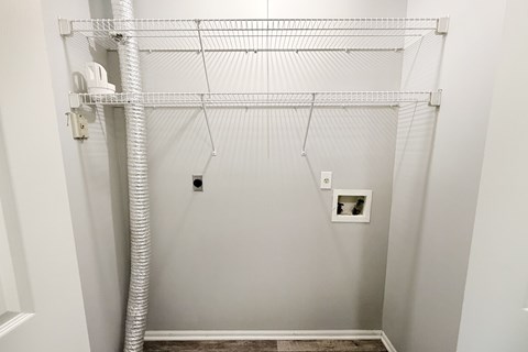 A white closet with a white pipe and a white shelf.