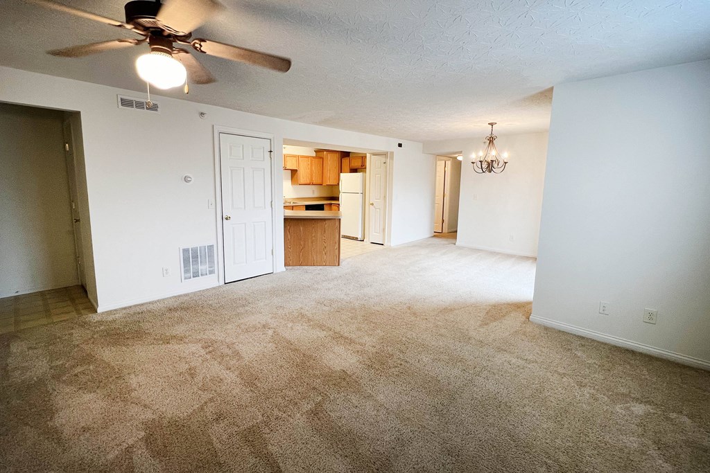 an empty living room with a ceiling fan and a kitchen  at Walton Ridge Apartments, Walton, Kentucky