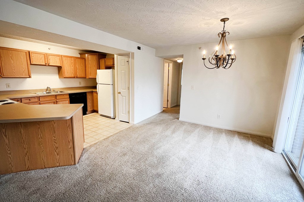 an empty living room with a kitchen and a chandelier  at Walton Ridge Apartments, Walton, KY, 41094