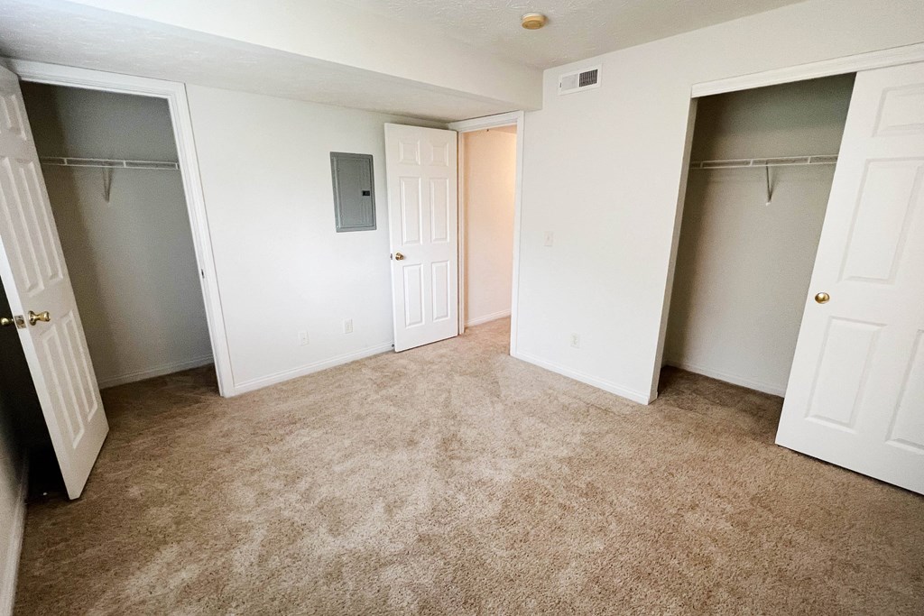 an empty bedroom with two closets and a carpeted floor  at Walton Ridge Apartments, Walton