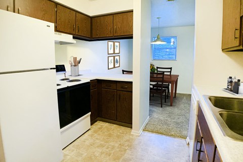 a kitchen and dining room with a refrigerator and a sink