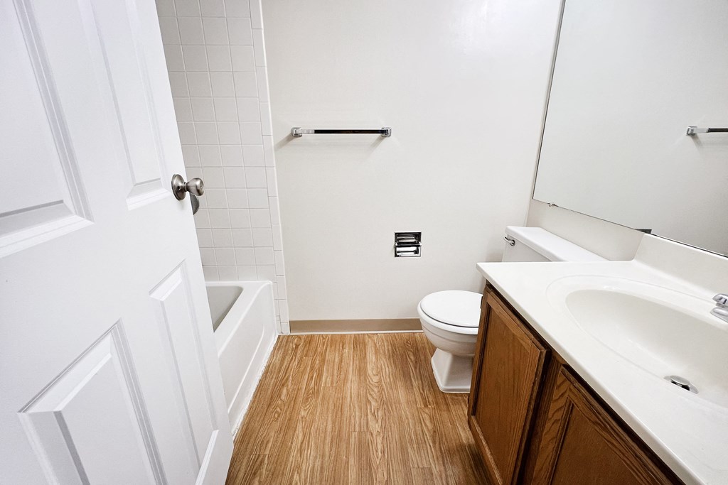 an empty bathroom with a toilet and a sink  at Deercross Apartments, Ohio