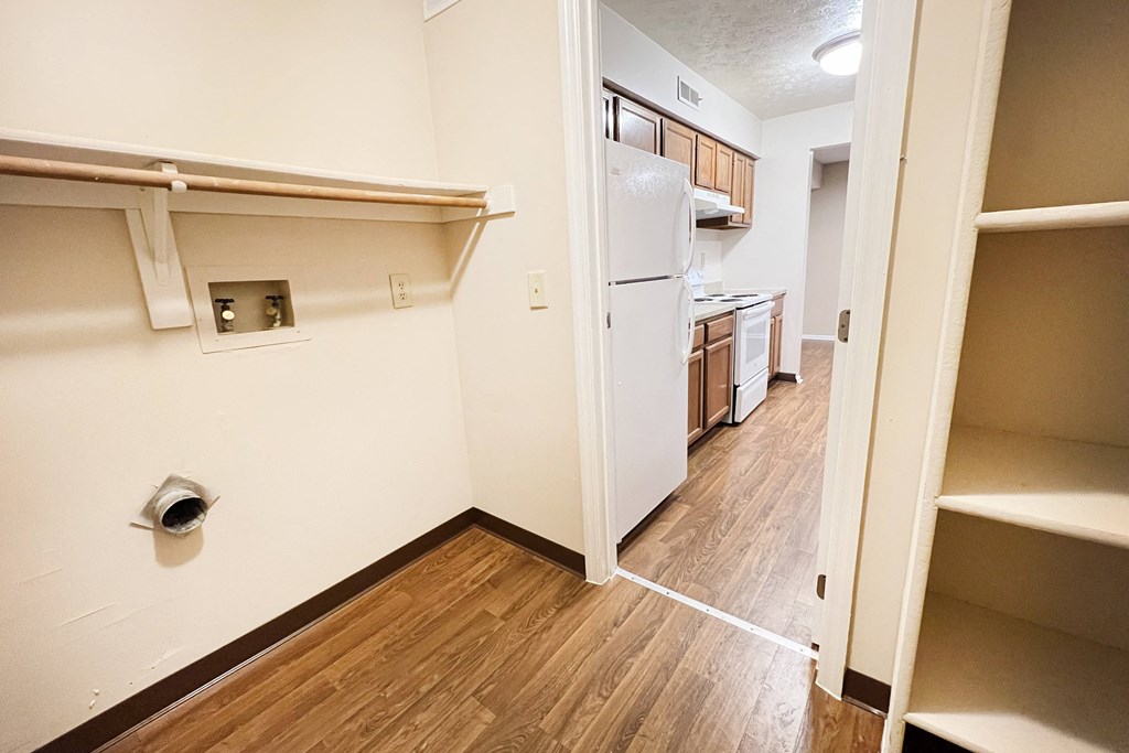 a view of a kitchen and a hallway with wood flooring and a white refrigerator  at Deercross Apartments, Cincinnati