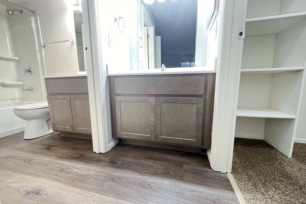 a bathroom with a toilet and a vanity with a mirror  at Deercross Apartments, Cincinnati