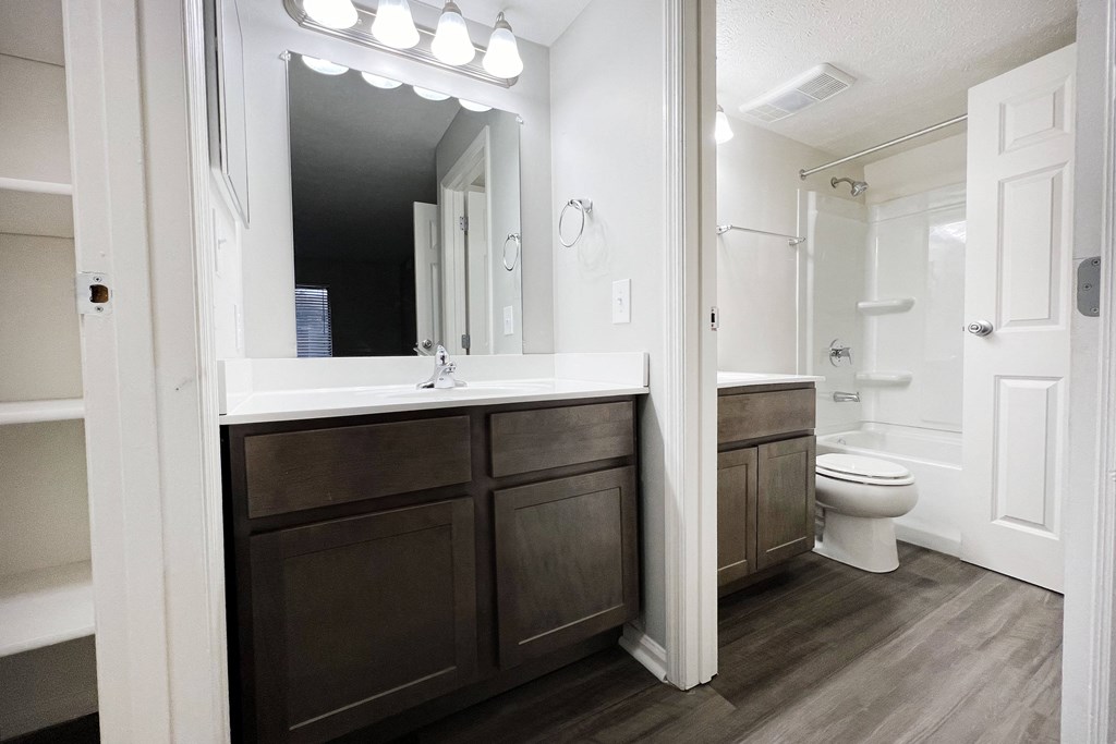 a bathroom with a sink and a toilet and a mirror  at Deercross Apartments, Cincinnati, 45236