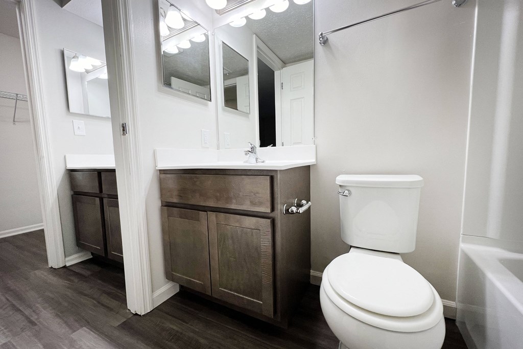 a bathroom with a toilet and a sink and a mirror  at Deercross Apartments, Cincinnati, OH, 45236