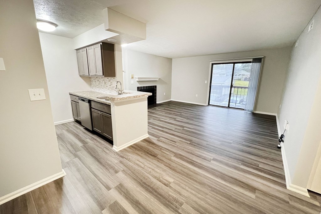 an empty living room and kitchen with wood flooring  at Deercross Apartments, Ohio