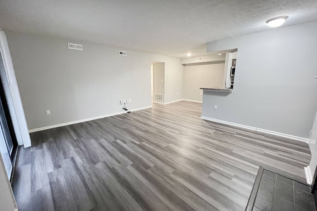 the living room and dining room of an apartment with wood flooring  at Deercross Apartments, Ohio
