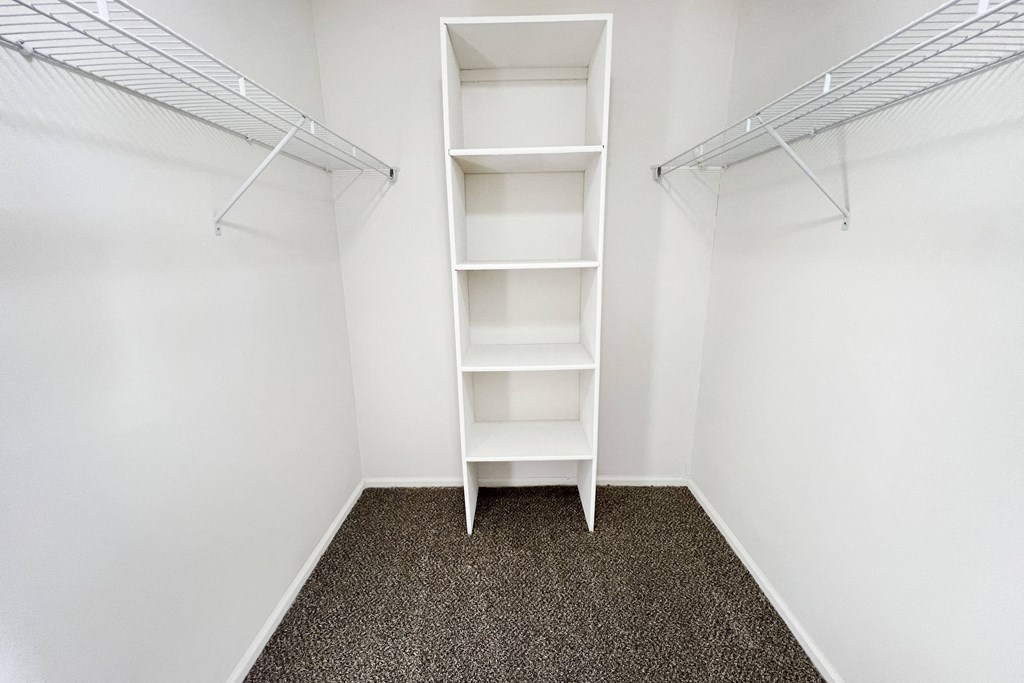 an empty closet in a room with white walls and shelves  at Deercross Apartments, Cincinnati