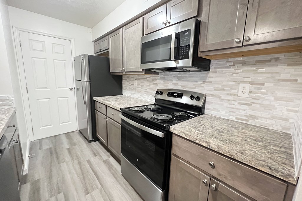 an updated kitchen with stainless steel appliances and marble counter tops  at Deercross Apartments, Ohio