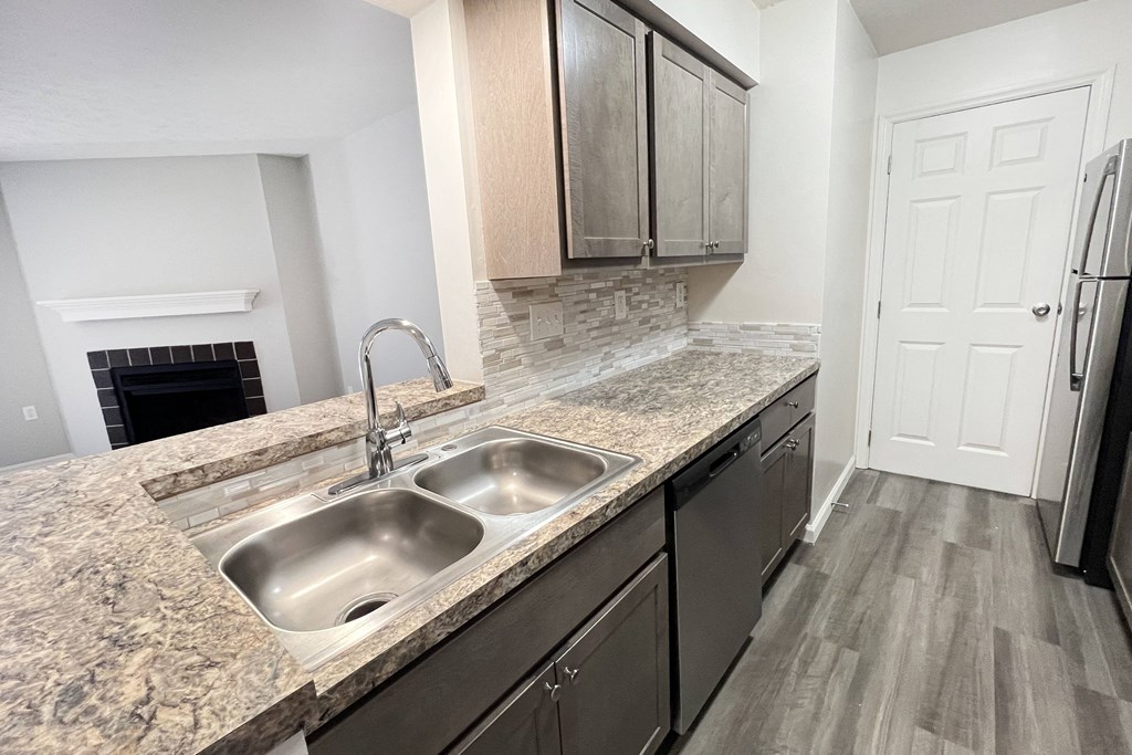 a kitchen with granite counter tops and a stainless steel sink  at Deercross Apartments, Ohio, 45236