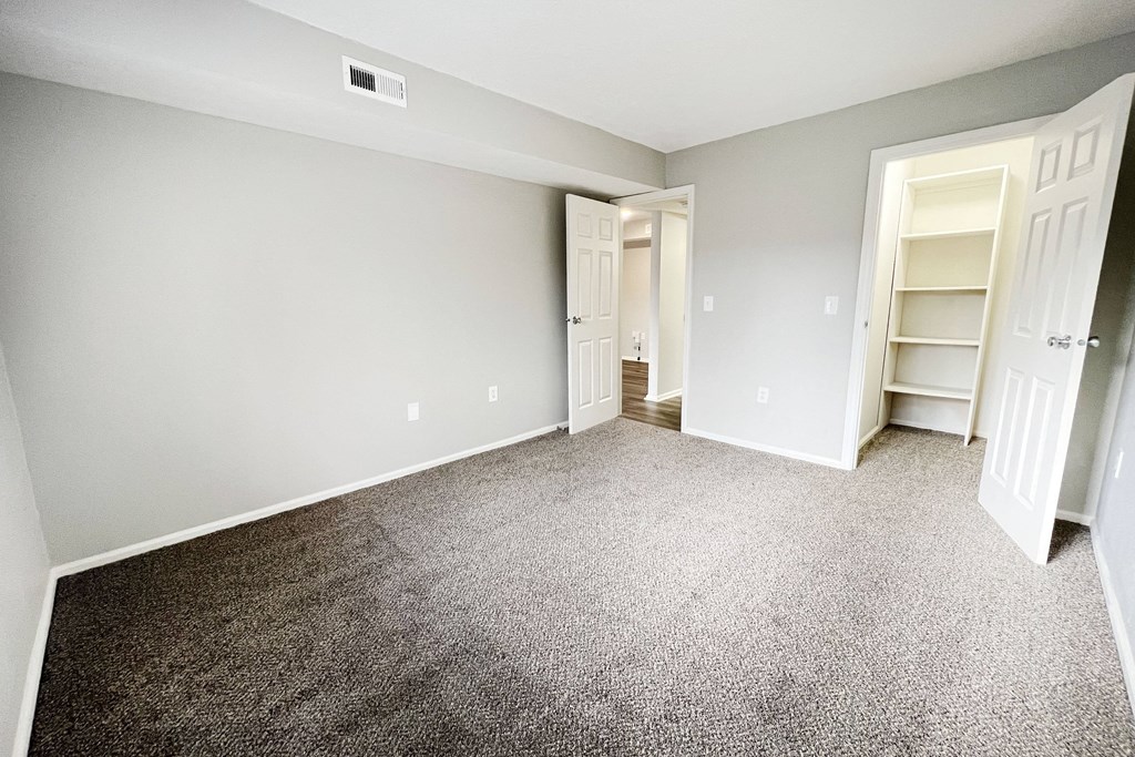 an empty bedroom with carpeting and a closet  at Deercross Apartments, Ohio