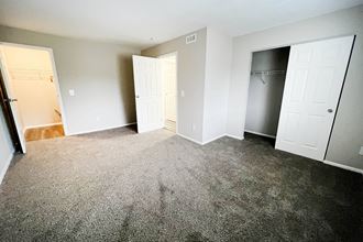 an empty bedroom with a closet and a door open