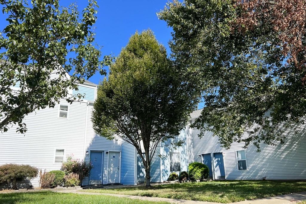 a large white building with blue doors and a tree in front of it at 450 on Keeneland, Kentucky, 40475