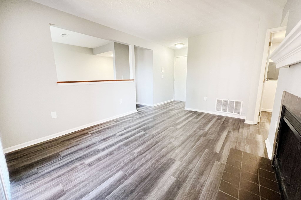 the living room and dining room of an apartment with wood flooring  at Deercross Apartments, Ohio