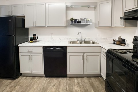 a kitchen with white cabinets and black appliances