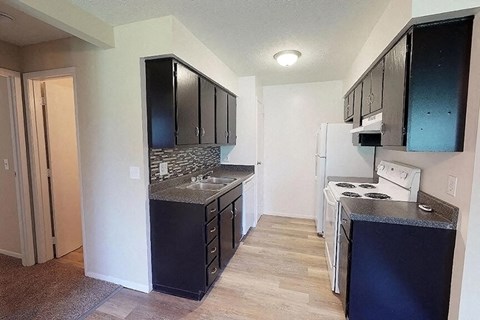 a kitchen with black cabinets and white appliances
