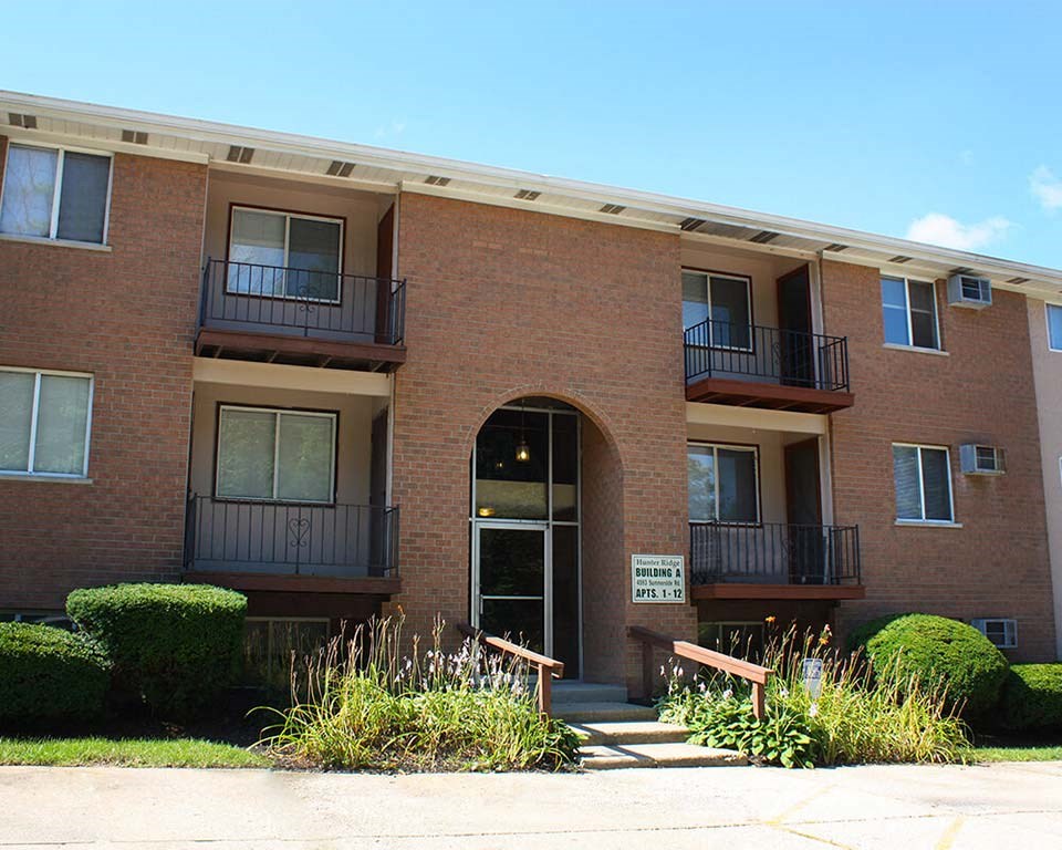 a red brick apartment building with an arched doorway at Hunter Ridge Apartments, Cincinnati
