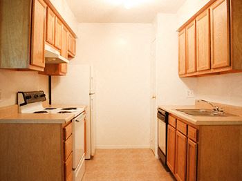 a kitchen with wooden cabinets and white appliances at Hunter Ridge Apartments, Cincinnati