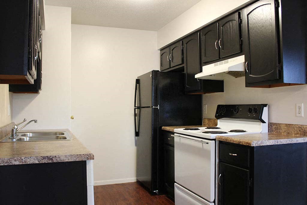 a kitchen with a white stove top oven next to a refrigerator at Hunter Ridge Apartments, Cincinnati, OH