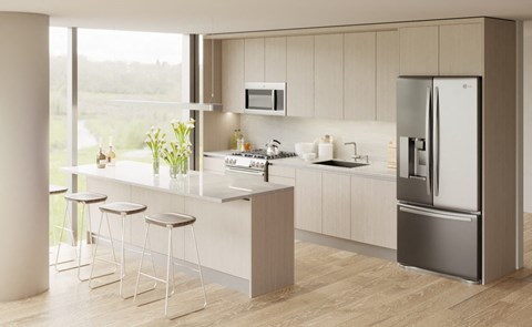 a kitchen with a island and stainless steel refrigerator