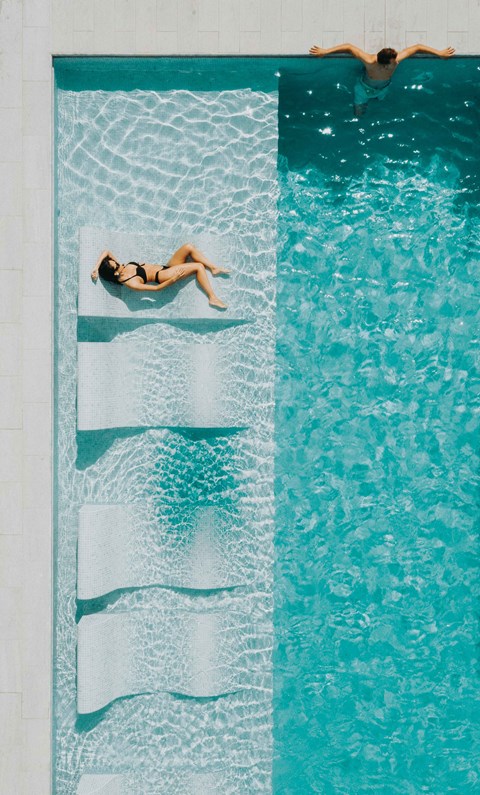 a woman laying on a towel in a swimming pool