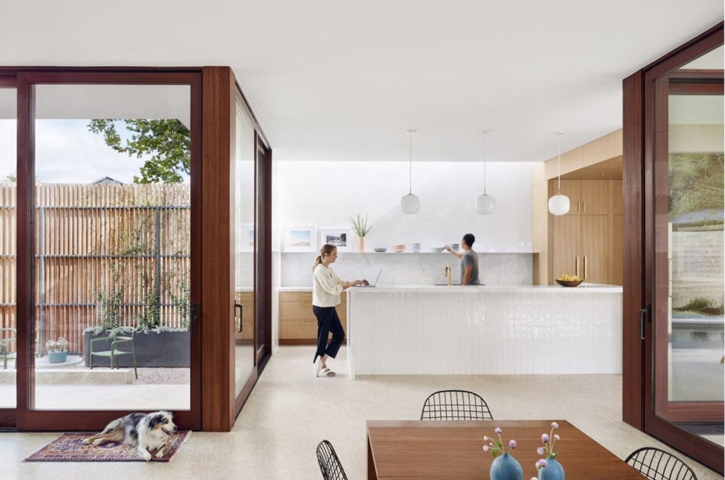 a kitchen with a white counter and a person in it