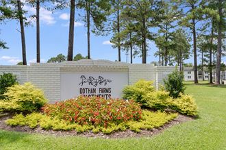 a sign that says dothan farms in front of a building with trees in the background