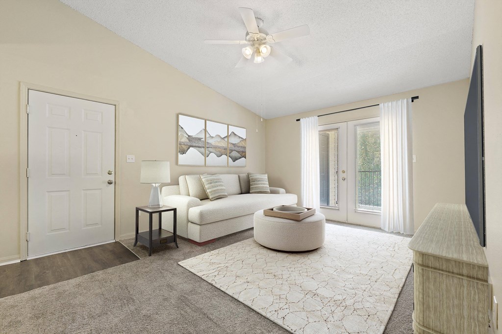 a living room with a white couch and a ceiling fan