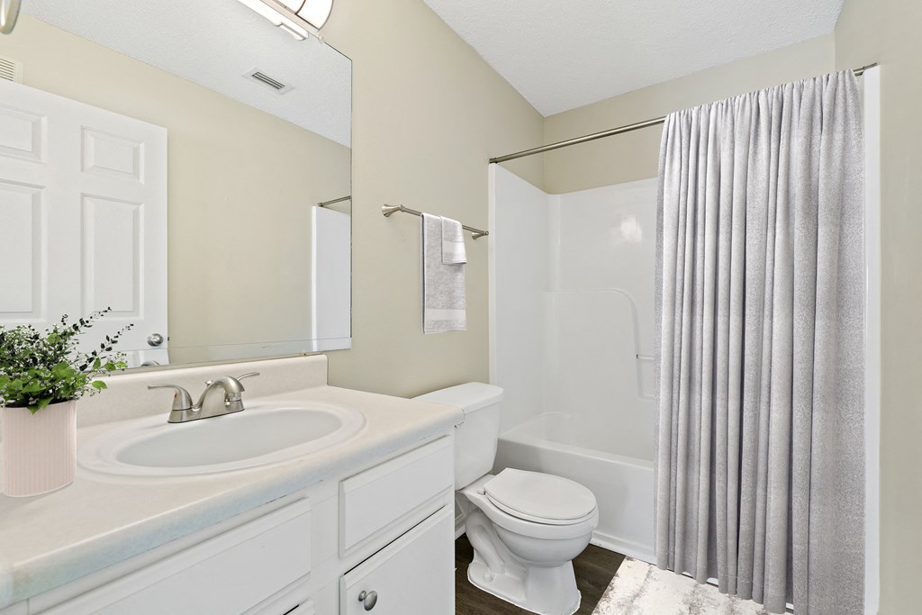a white bathroom with a shower toilet and sink