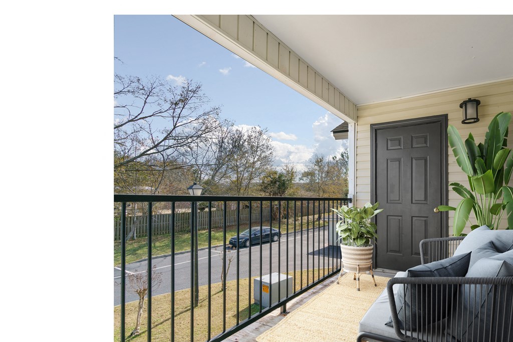 a porch with a black railing and a black door