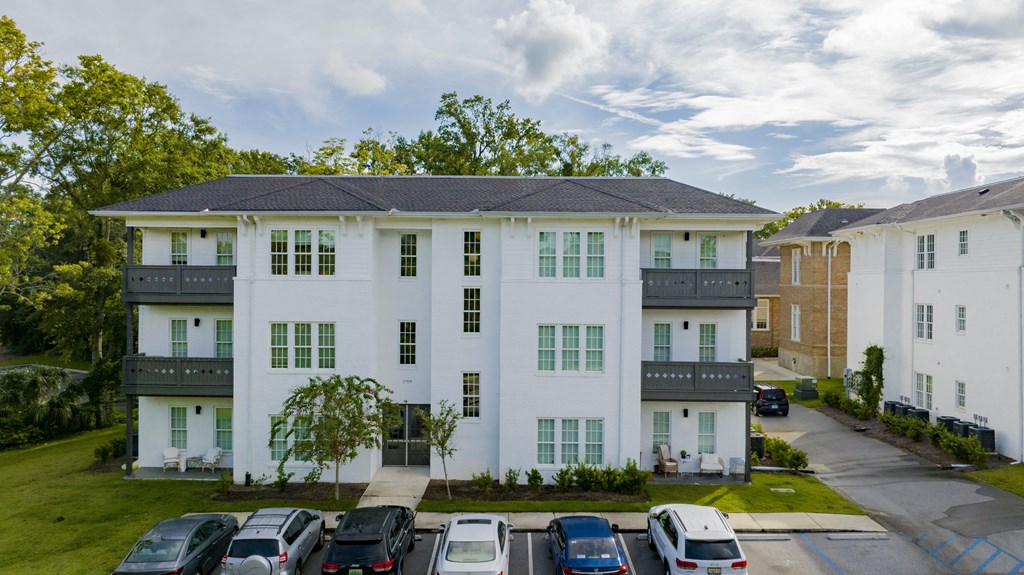 a white apartment building with cars parked in front of it