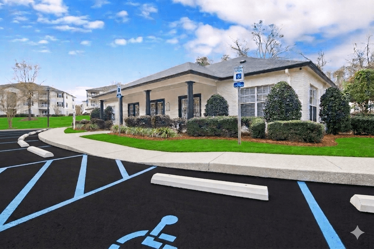 A parking lot with a handicap parking sign in front of a building.
