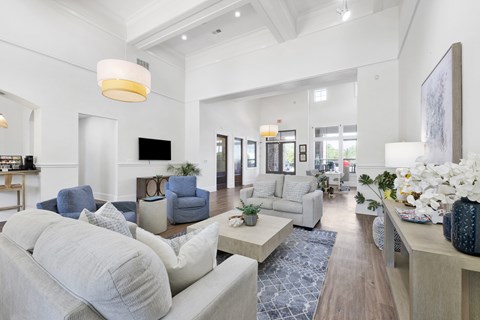 A spacious living room with a grey sofa and a white couch.