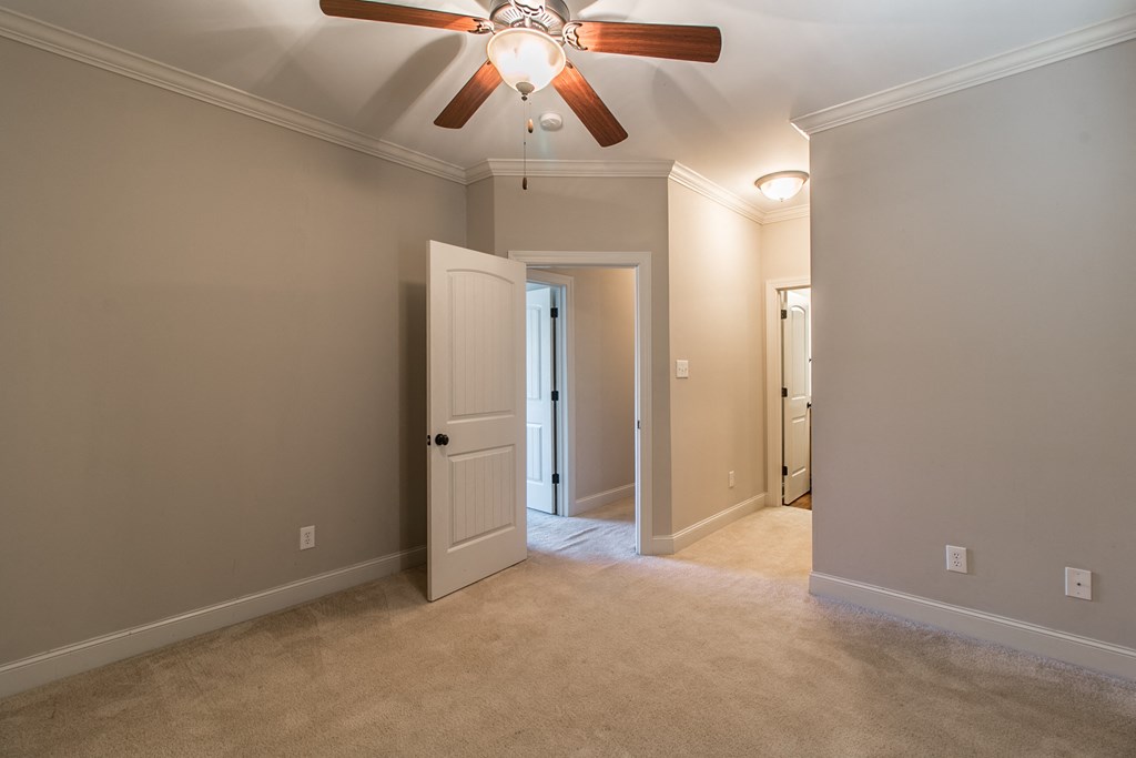 a bedroom with a ceiling fan and a door to a closet