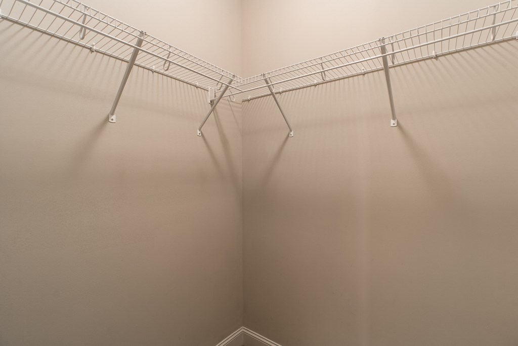 the walk in closet is empty and has a wire shelf on the wall