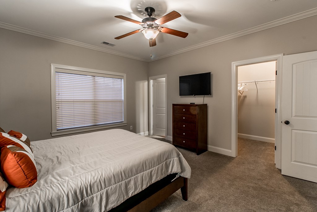 a bedroom with a bed and a ceiling fan