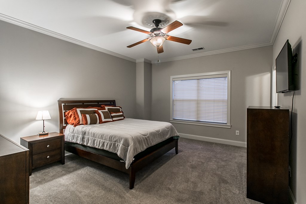 a bedroom with a bed and a ceiling fan