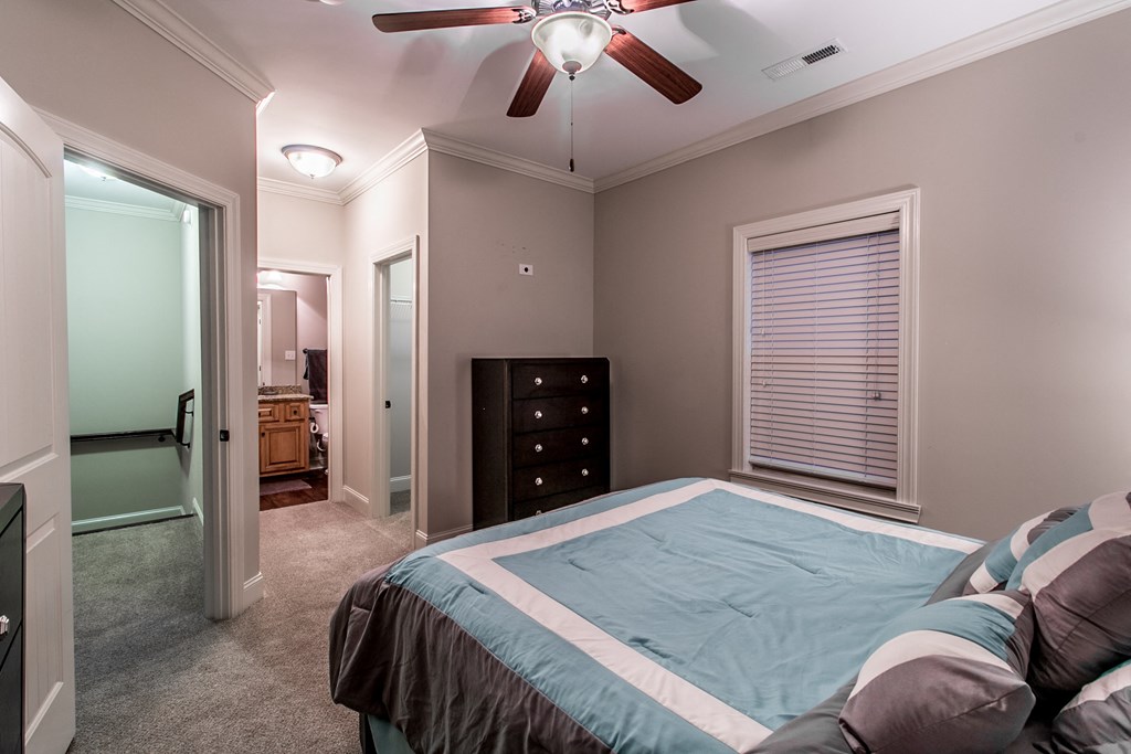 a bedroom with a large bed and a ceiling fan