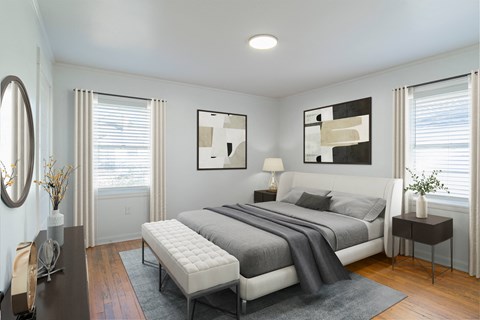 a bedroom with a bed and two windows at Ann Street Lofts, Alabama