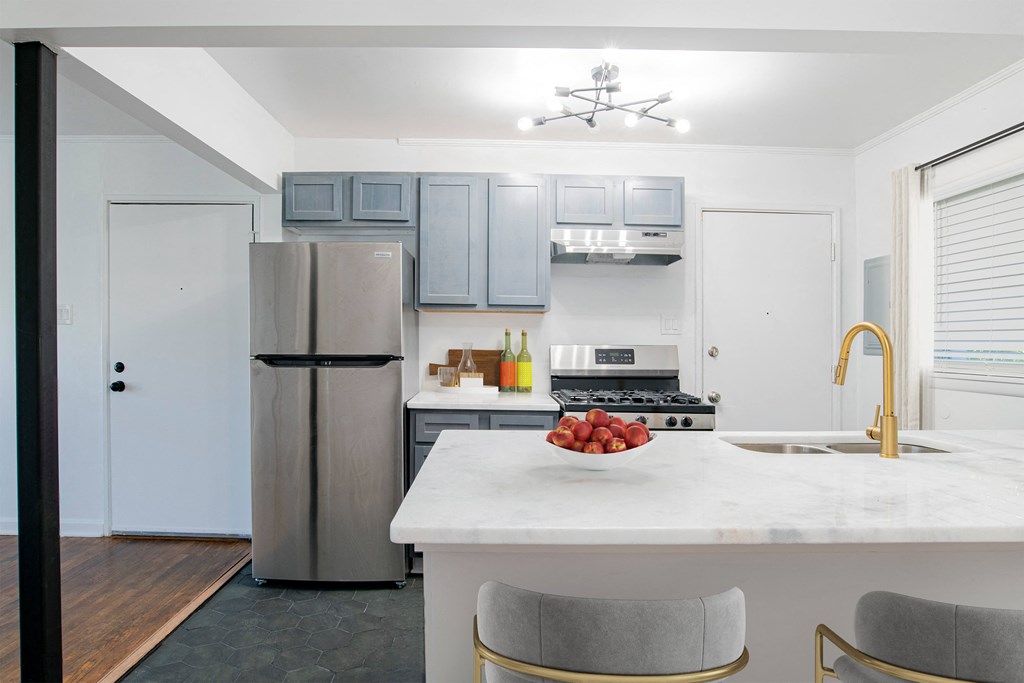 a kitchen with a marble counter top and stainless steel refrigerator a kitchen with a marble counter top and stainless steel refrigerator at Ann Street Lofts, Mobile