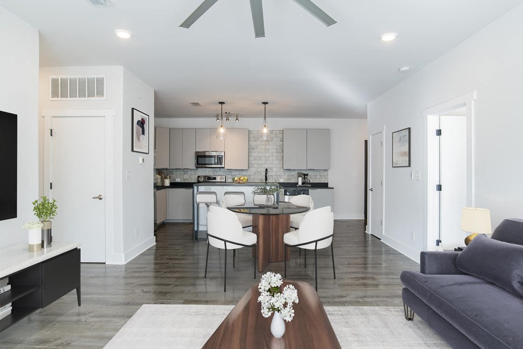 a living room and kitchen with a table and chairs